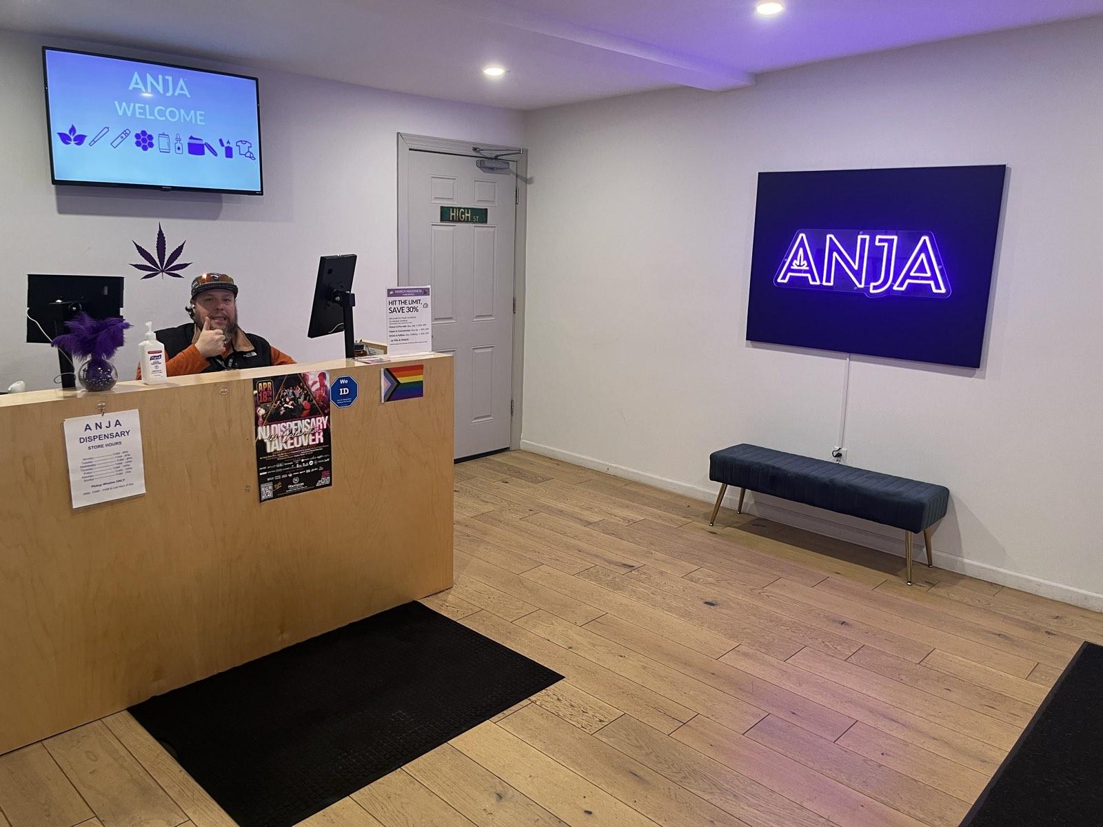 Welcome desk and ANJA neon sign inside ANJA, the Highland Park NJ cannabis dispensary